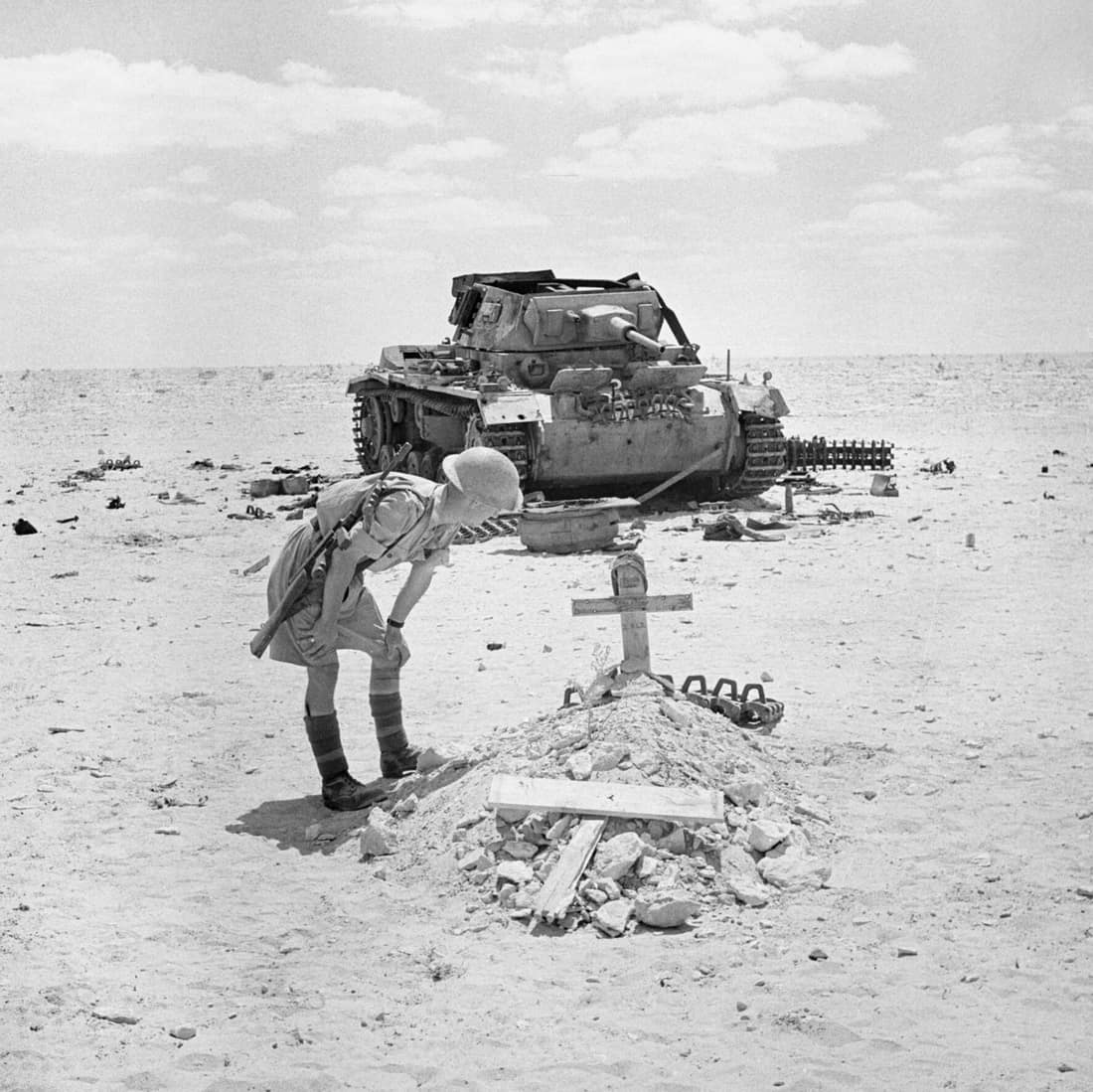 A British soldier inspects the grave of a German tank crewman, killed when his PzKpfw III tank was knocked out in the Western Desert, 29 September 1942. A soldiers stops to inspect the grave of a German tank crew, killed