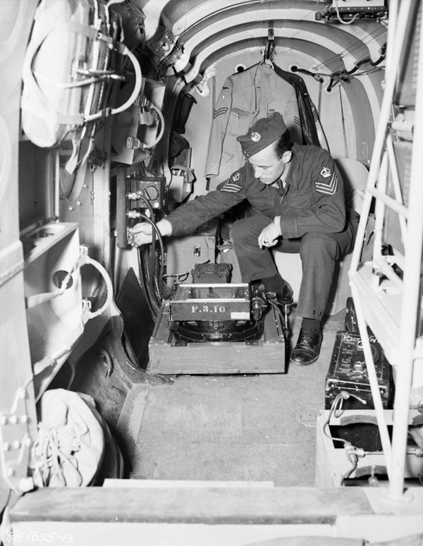 Sergeant, No. 14 (P) Squadron, RCAF, installing a vertical camera in an Avro Anson V, Rockcliffe, Ont., July 4, 1944