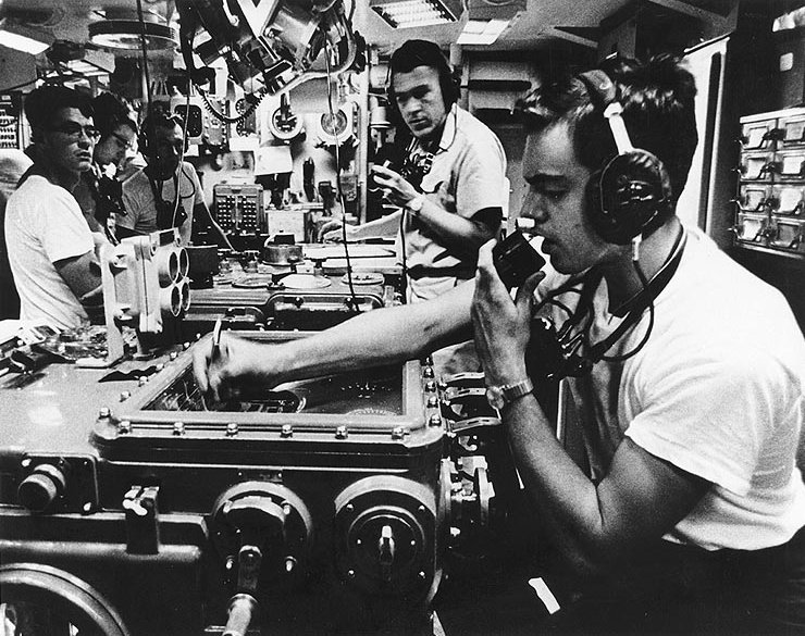U.S. Navy crewmen in the Main Battery Plot of the guided missile cruiser USS Canberra (CAG-2) work to obtain firing solutions from the ship's fire control computers, during bombardment operations off Vietnam, in March 19