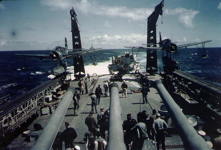 Two Vought OS2U "Kingfisher" floatplanes warming up on the fantail of the U.S. Navy heavy cruiser USS Quincy (CA-71) prior to catapult launching, probably at the time of the Invasion of Southern France, August 1944. Note