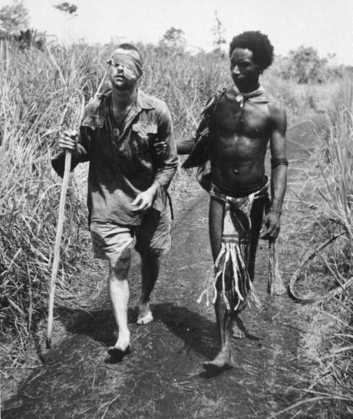 George Silk's classic picture taken at Buna, New Guinea, on Christmas Day, 1942. An Australian soldier, Private George "Dick" Whittington is aided by a Papuan orderly, Raphael Oimbari. Whittington died in February 1943 f