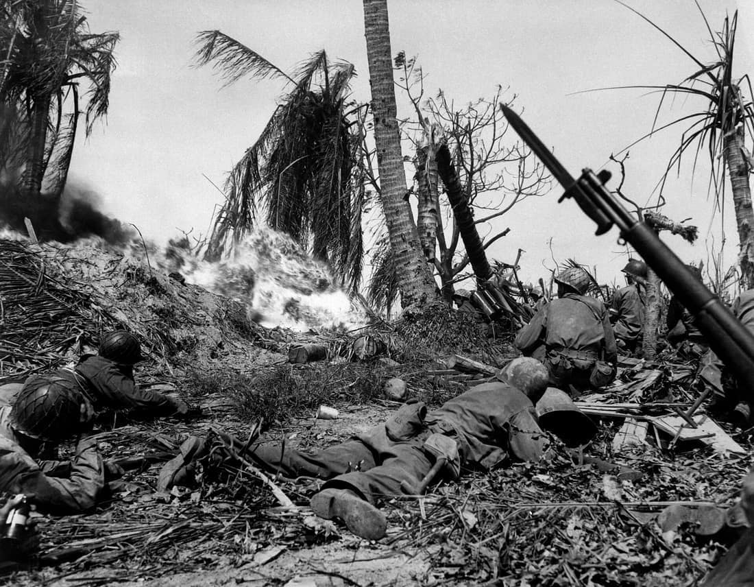 Men of the 7th Div. using flame throwers to smoke out Japanese soldiers from a block house on Kwajalein Island, while others wait with rifles ready in case soldiers come out. February 4, 1944. Cordray. (Army) NARA FILE #