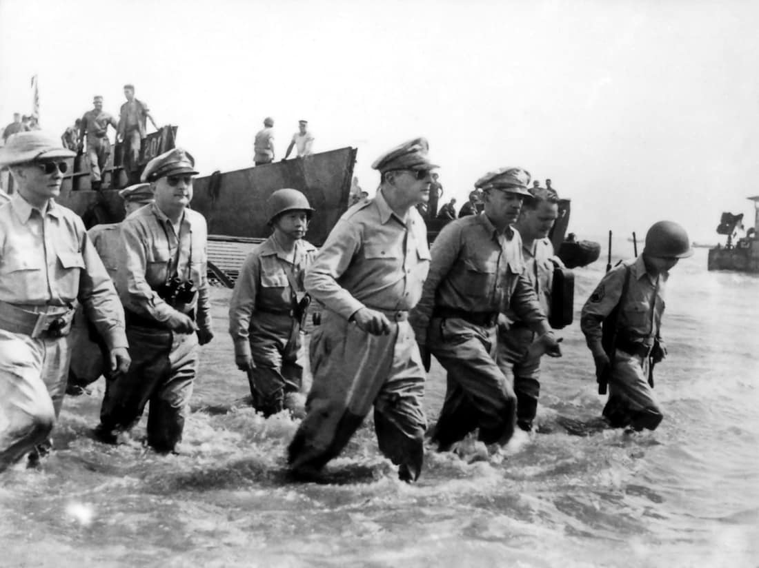 Douglas MacArthur wades ashore during initial landings at Leyte, Philippine Islands. Left to right: Philippine President Sergio Osmena; Lieutenant General George Kenney (obscured); Colonel Courtney Whitney; Brigadier Gen