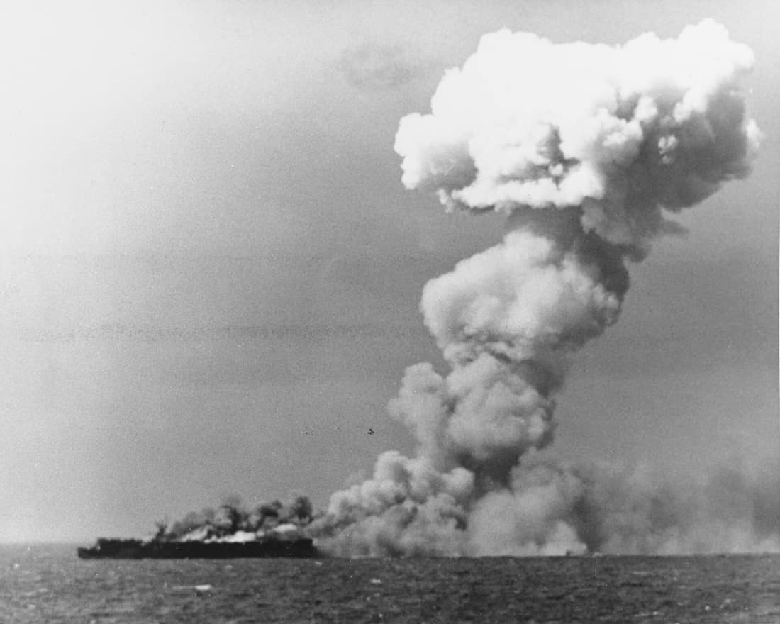 The U.S. Navy light aircraft carrier USS Princeton (CVL-23) burning soon after she was hit by a Japanese bomb while operating off the Philippines on 24 October 1944. This view, taken from the battleship USS South Dakota 