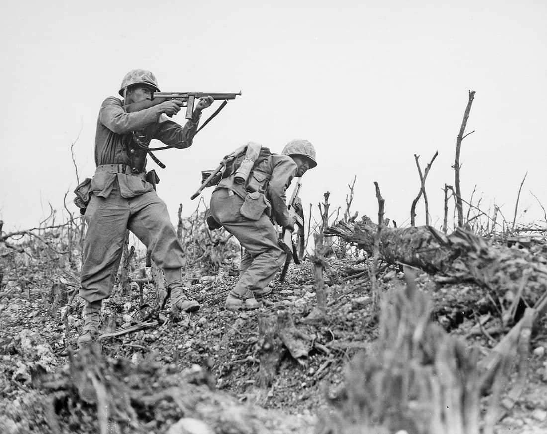 Two Marines from the 2nd Battalion, 1st Marine Regiment during fighting at Wana Ridge during the Battle of Okinawa, May 1945. On the left, Davis Hargraves (1926–2011) provides covering fire with his M1 Thompson submachin