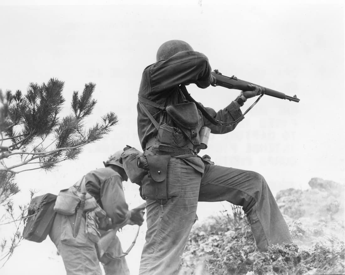 One rifleman reloads, and another fires in the 96th Infantry Division's advance to capture Big Apple Hill, scene of intense fighting on Okinawa.