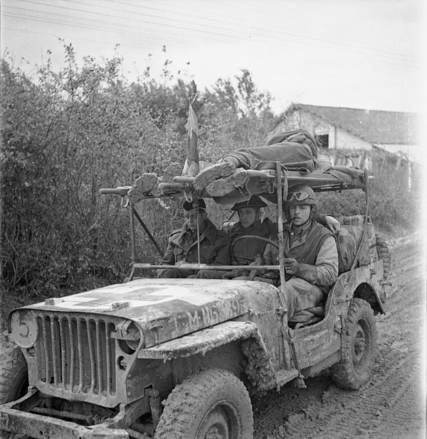 A jeep ambulance of the Royal Canadian Army Medical Corps (R.C.A.M.C.) bringing in two wounded Canadian soldiers on the Moro River front, south of San Leonardo di Ortona, Italy, December 10, 1943