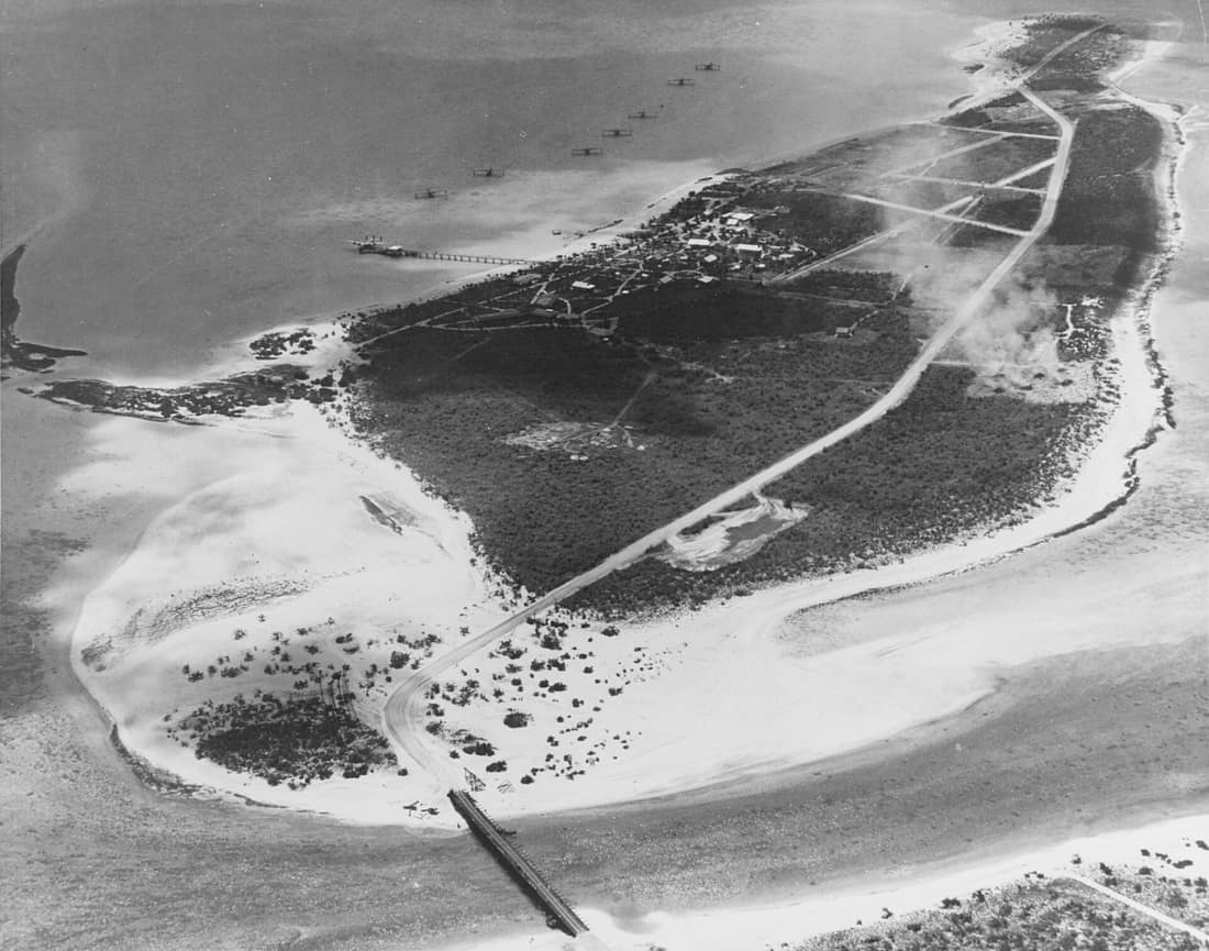 Wake Atoll: View of Peale Island, Wake, taken 25 May 1941. Seven U.S. Navy Consolidated PBY patrol planes are anchored in the lagoon, and a Pan American Airways Boeing "Clipper" is docked at the pier. The Pan American co
