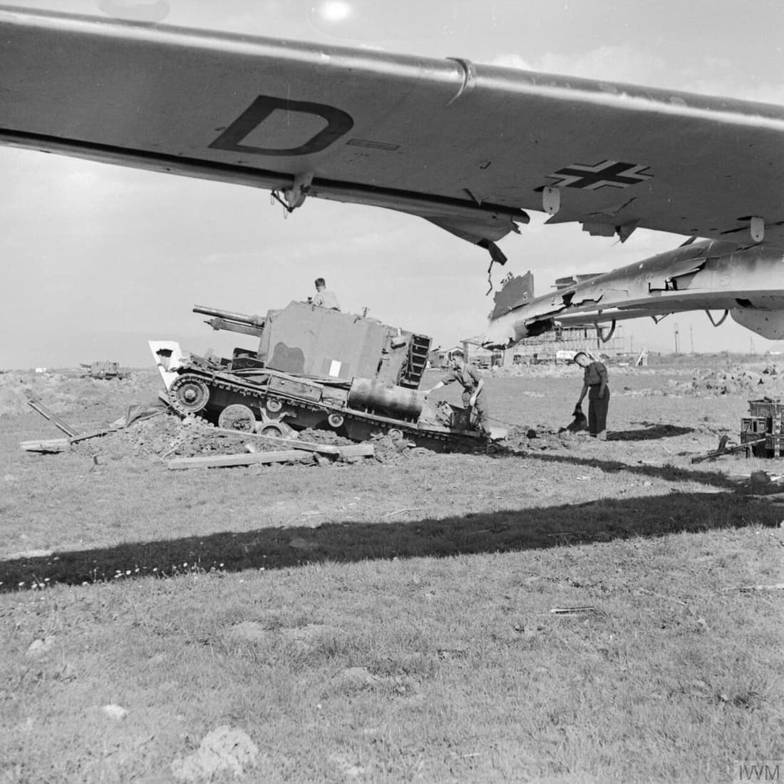 The British Army in Italy 1943 A Bishop 25-pdr self-propelled gun of 142nd Field Regiment Royal Artillery operating at a captured airfield among the wreckage of German Gotha Go 242 aircraft, 12 October 1943.