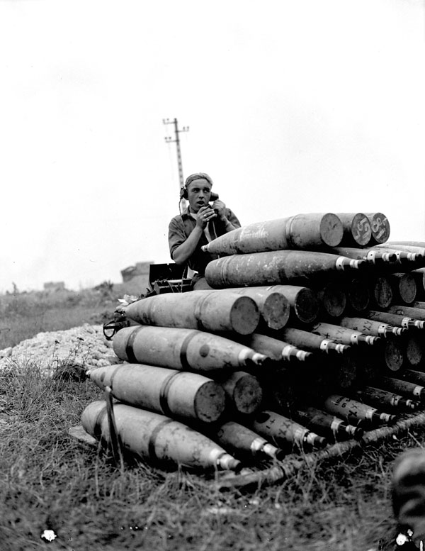 LAC caption : Unidentified signaller receiving the order to fire a 5.5-inch gun of a Medium Regiment of the Royal Canadian Artillery (R.C.A.) south of Vaucelles, France. Comment : The photograph also shows a stack of she