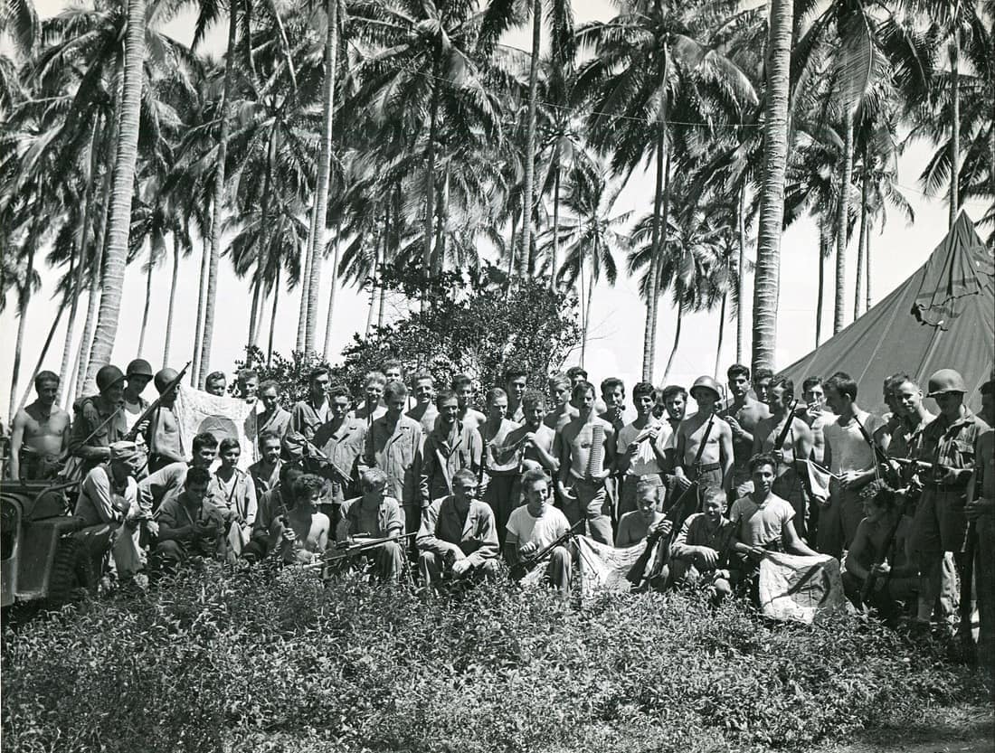 “RAIDER UNIT LEADER WITH MEN--- Colonel Carlson poses with members of the raider battalion he commands, and they show weapons and equipment captured after meeting and defeating [the Japanese].” From the Thayer Soule Coll