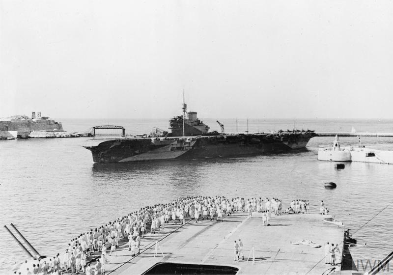 BIG SHIPS AT MALTA. OCTOBER 1943, ON BOARD HMS FORMIDABLE AT GRAND HARBOUR, VALLETTA, MALTA. The aircraft carrier HMS ILLUSTRIOUS steams into Grand Harbour, as men line the flight deck of HMS FORMIDABLE to watch her prog