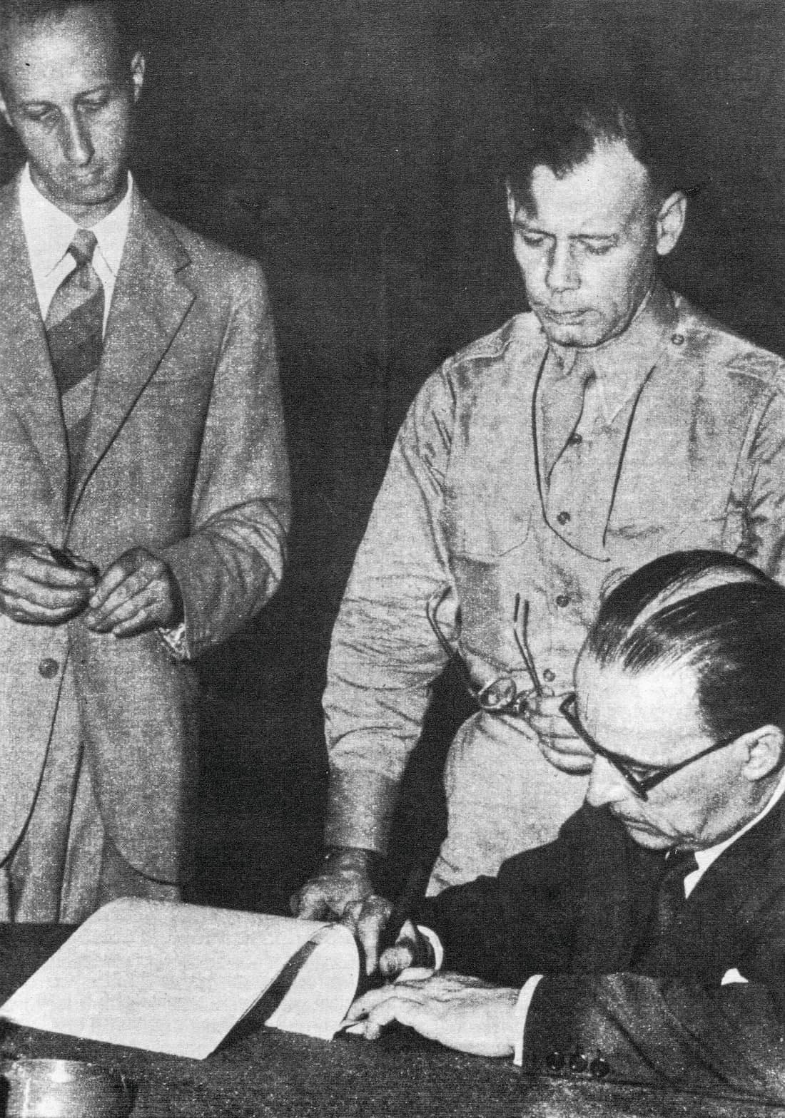 Franco Montanari (standing, left), Walter Bedell Smith (standing, right), and Giuseppe Castellano (seated), signing the armistice on behalf of Badoglio.