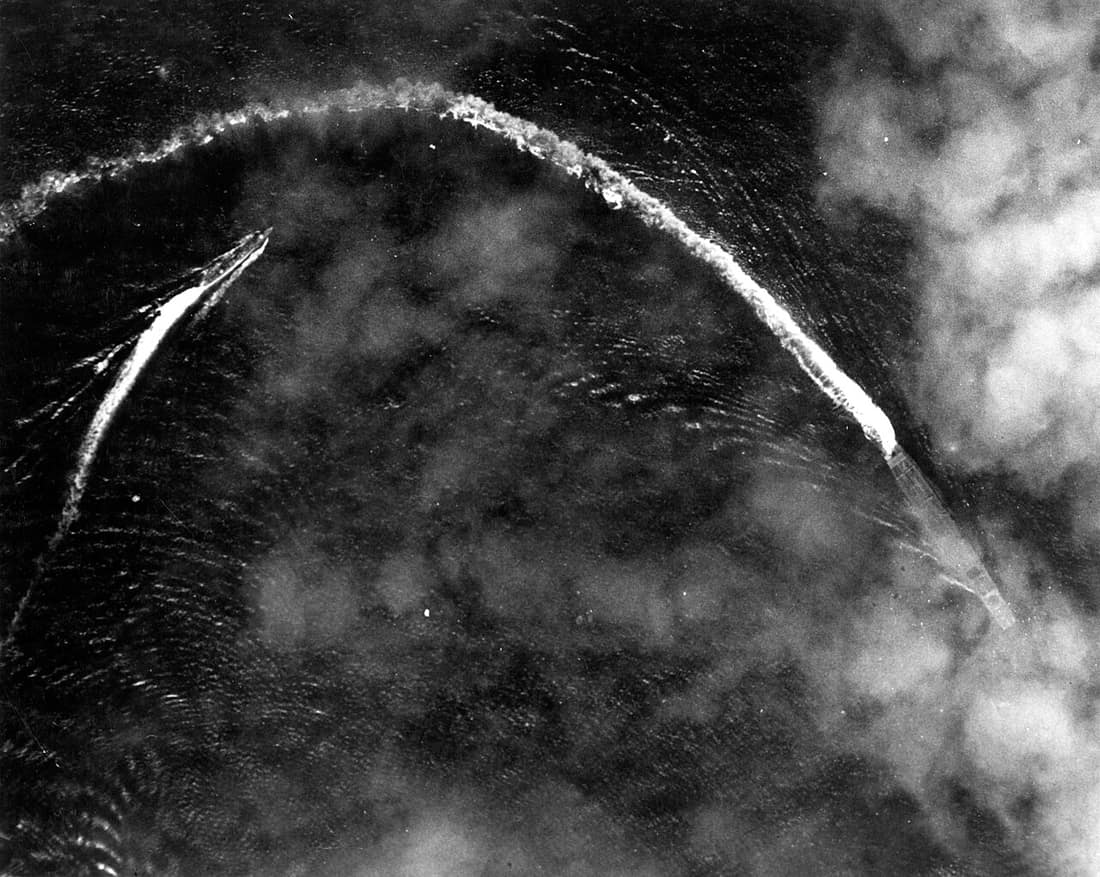 The Japanese aircraft carrier Akagi and the destroyer Nowaki maneuvering below thin clouds while under high-level bombing attack by U.S. Army Air Forces Boeing B-17E Flying Fortress bombers, shortly after 0800 hrs, 4 Jun