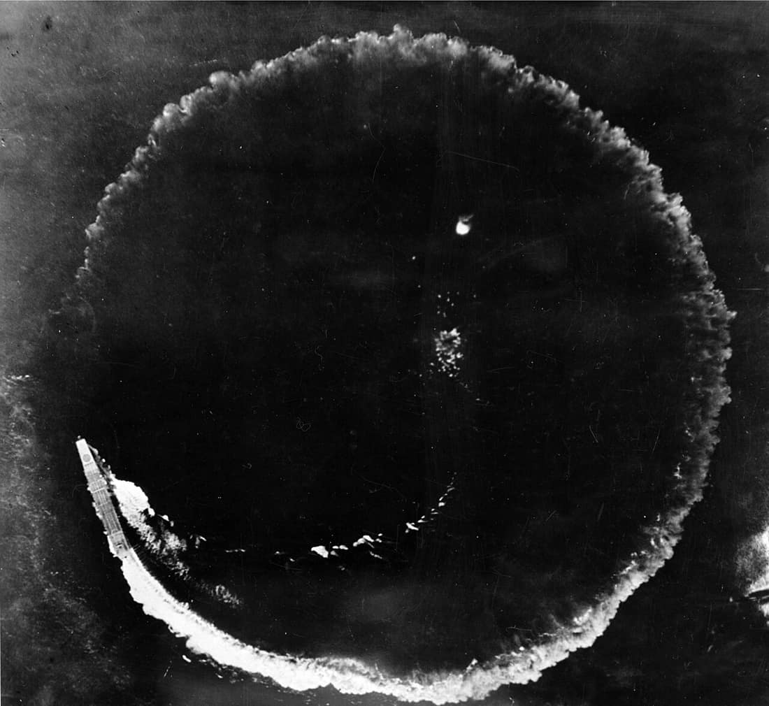 Aerial photograph of the Japanese aircraft carrier Sōryū and its circular wake during the Battle of Midway. The ship was circling as an evasion maneuver while under attack from United States Army Air Forces Boeing B-17E 