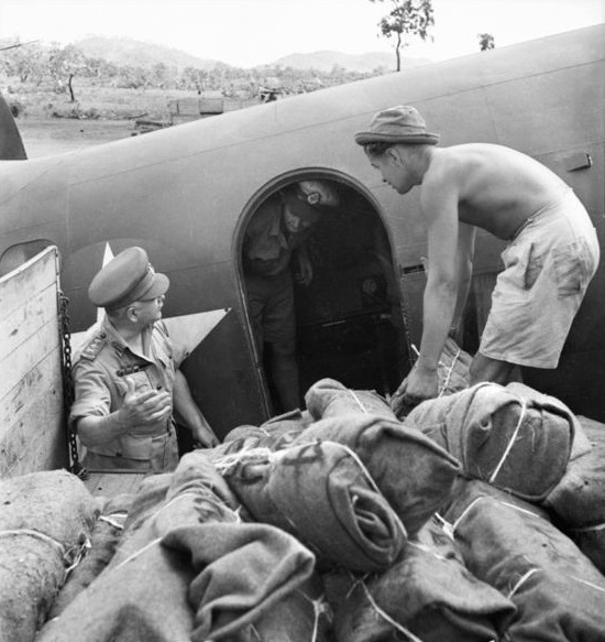 1942-12-14. NEW GUINEA. TROOPS LOAD PLANE WITH AMMUNITION WRAPPED IN BLANKETS, WHICH WILL BE DROPPED TO THE TROOPS IN THE BUNA-GONA AREA. GENERAL BLAMEY DISPLAYS KEEN INTEREST IN THE LOADING OF THE PLANE. (NEGATIVE BY G.
