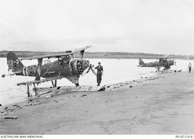 Two damaged Mitsubishi F1M2 (Allied code name "Pete") observation seaplanes beached at the former Japanese seaplane base at Rekata Bay on the northern end of Santa Isabel island in March 1944. The man standing on the flo