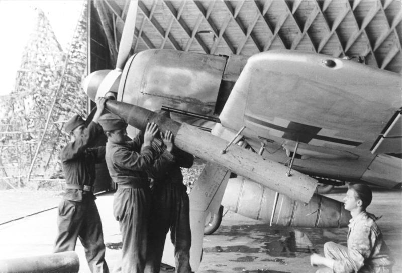 Information added by Wikimedia users. Beladen einer Fw 190 A-8 mit 21-cm-Werfergranaten (WfG. 21) zur Abwehr von schweren Bombern. Unter dem Rumpf trägt die Maschine am ETC-501-Rumpfpylon einen 300-l-Zusatztank.