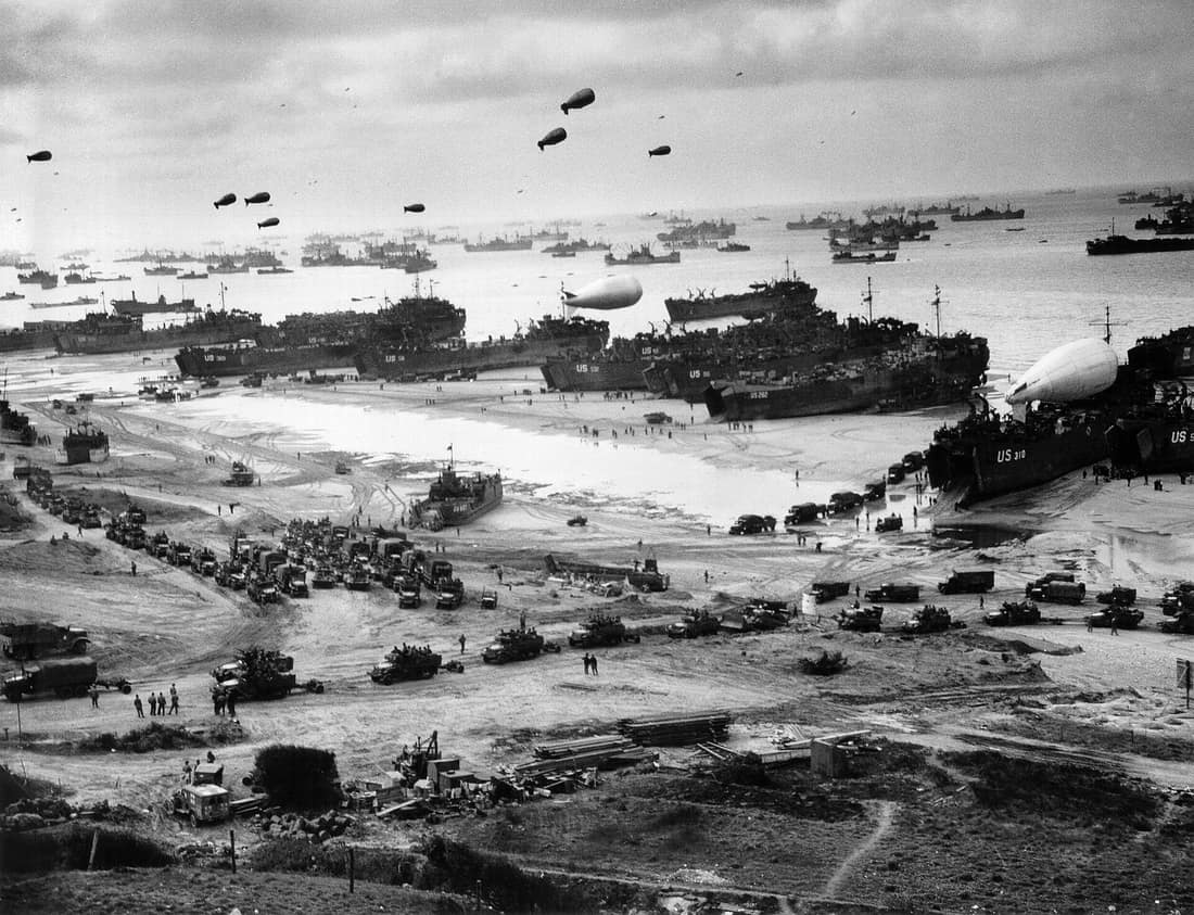 Landing ships putting cargo ashore on Omaha Beach at low tide during the early days of the Allied invasion, mid-June 1944. Among identifiable ships present are LST-532 (in the center of the view); USS LST-262 (3rd LST fr