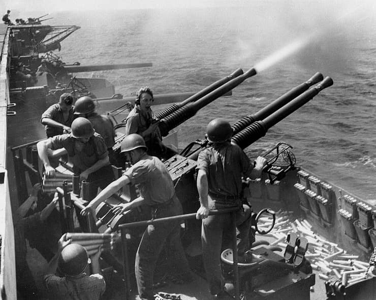 Bofors 40 mm anti-aircraft guns on a Mk 12 quadruple mount firing on board USS Hornet (CV-12), circa February 1945, probably during gunnery practice. The original picture caption identifies the photo as having been taken