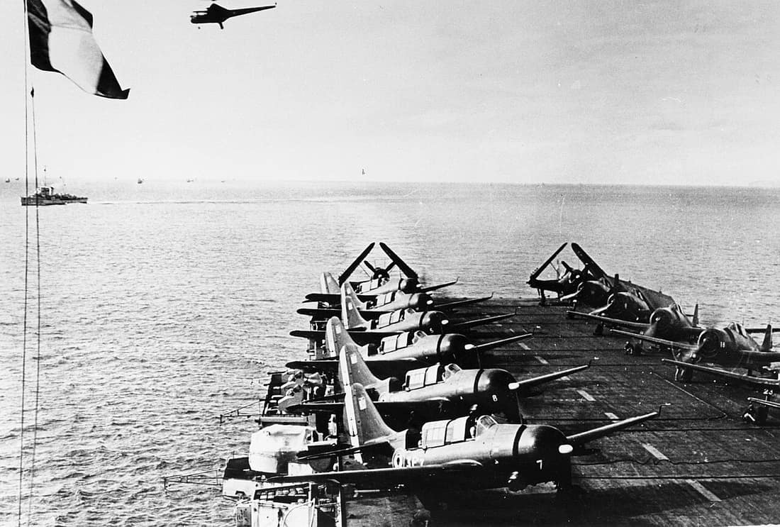 Eight Curtiss SB2C-5 Helldiver dive bombers (Escadrille 3F) and six Grumman F6F-5 Hellcat fighters (Escadrille 1F) on the flight deck of the French aircraft carrier Arromanches (R95) in the Gulf of Tonkin, circa 1951. Th