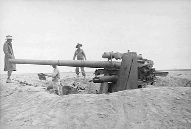 A German 88 mm FlaK 36 gun which had been used as a tank attack weapon near El Aqqaqir, Egypt. The whole crew were killed and were found buried alongside the gun. Allied Sherman and Crusader tanks can be seen on the skyl
