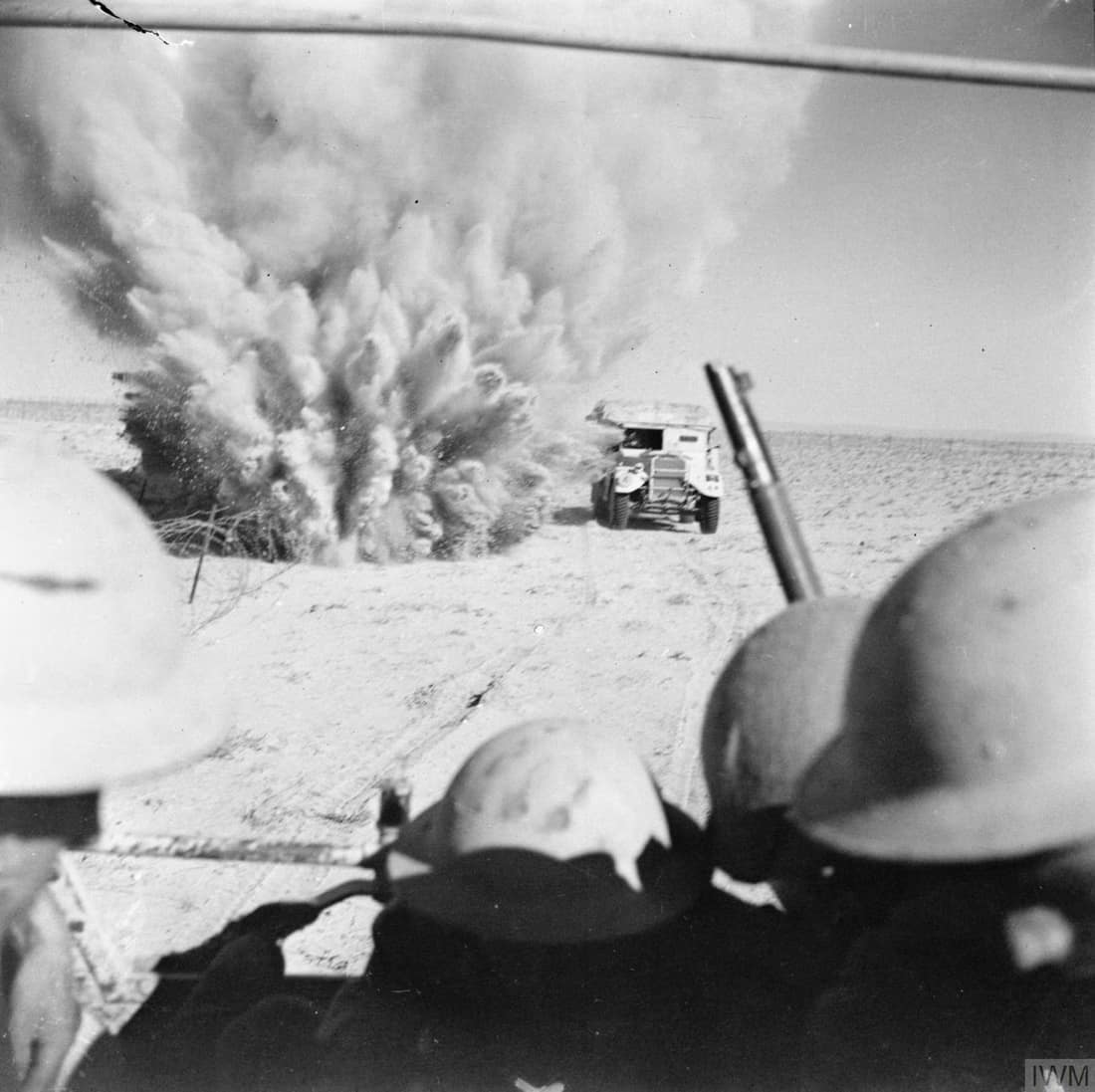 A mine explodes close to a British truck as it carries infantry through enemy minefields and wire to the new front lines.