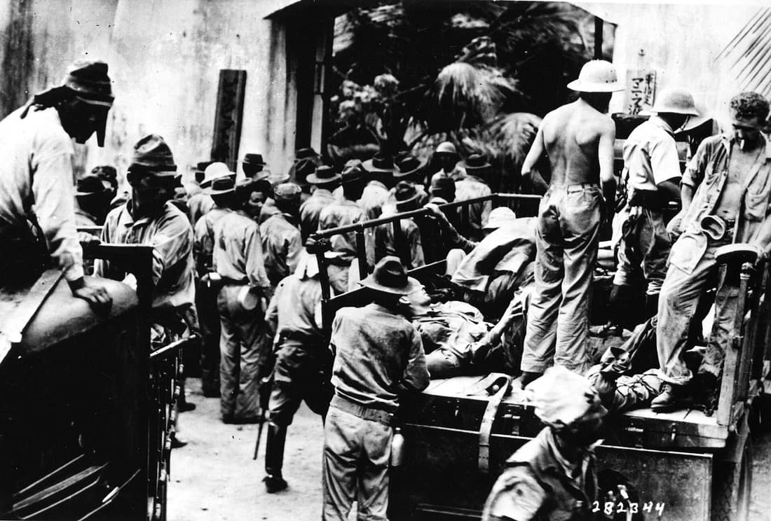 Scope and content: Original Caption: American and Filipino prisoners, captured at Corregidor, arrive at Bilibid prison by foot and truck as Japanese look on. They were taken by boat to Cavite. Those unable to walk were h