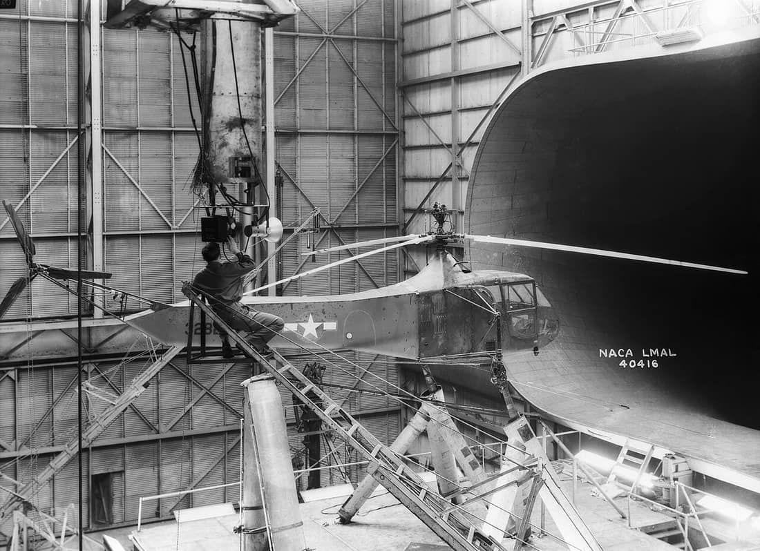 One of Langley's Sikorsky YR-4B/HNS-1 helicopters is seen in the 30 x 60 Full Scale Tunnel. The technician is setting up camera equipment for stopped-action rotor-blade photos. Sikorsky built hundreds of R-4 helicopters 