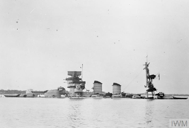 The Italian battleship CONTE DI CAVOUR after the Taranto attack. Only her funnels and super-structure remain above the water
