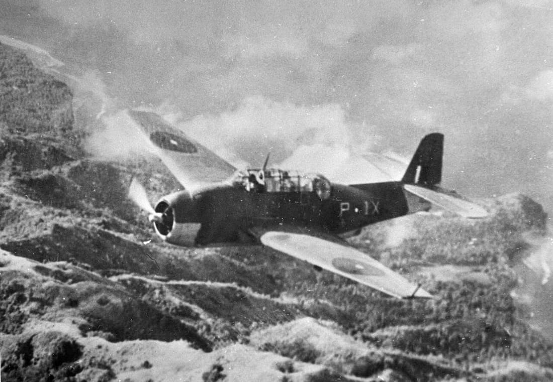 A Royal Navy Grumman Avenger Mk.II from 849 Naval Air Squadron based on the aircraft carrier HMS Victorious (R38), flying over an island in the Indian Ocean, ca. 1944.