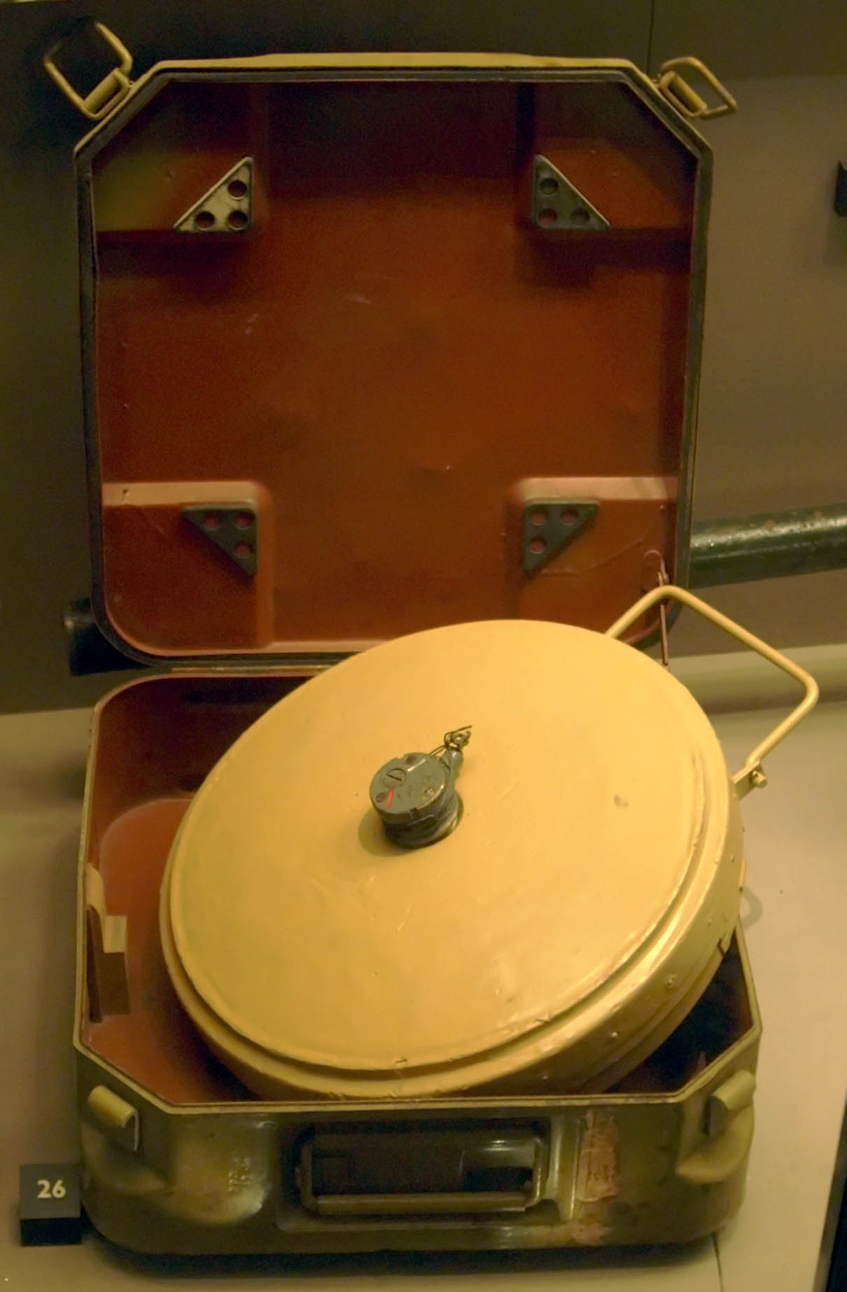 A German Second World War Tellermine 35 anti-tank Landmine and carry case at the Imperial War Museum, London. It is painted yellow, indicating that is a pre-war mine.