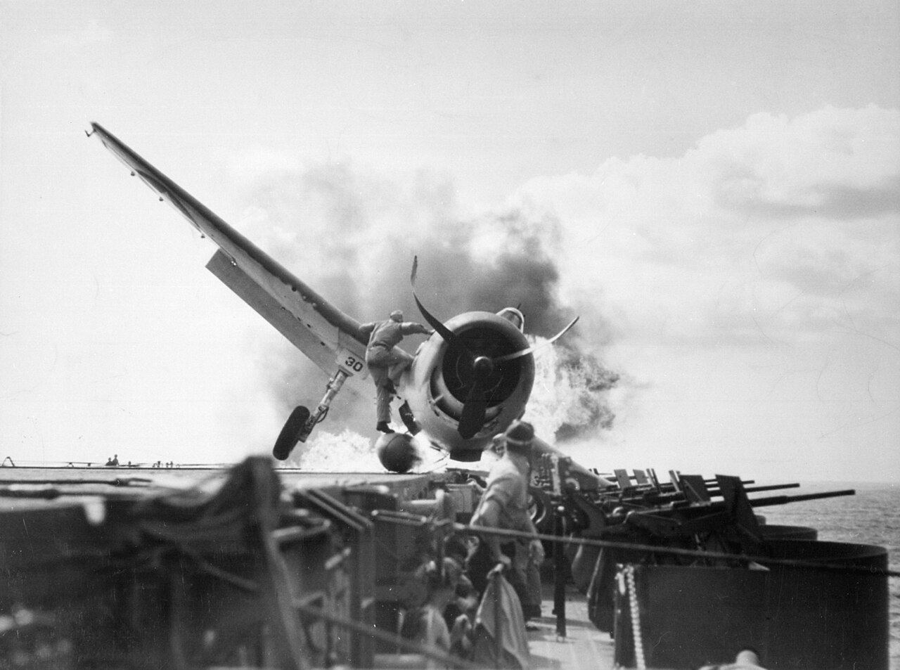 Crash landing of a U.S. Navy Grumman F6F-3 Hellcat (Number 30) of Fighting Squadron 2 (VF-2) aboard the aircraft carrier USS Enterprise (CV-6), into the carrier's port side 20mm gun gallery, 10 November 1943. Lieutenant 