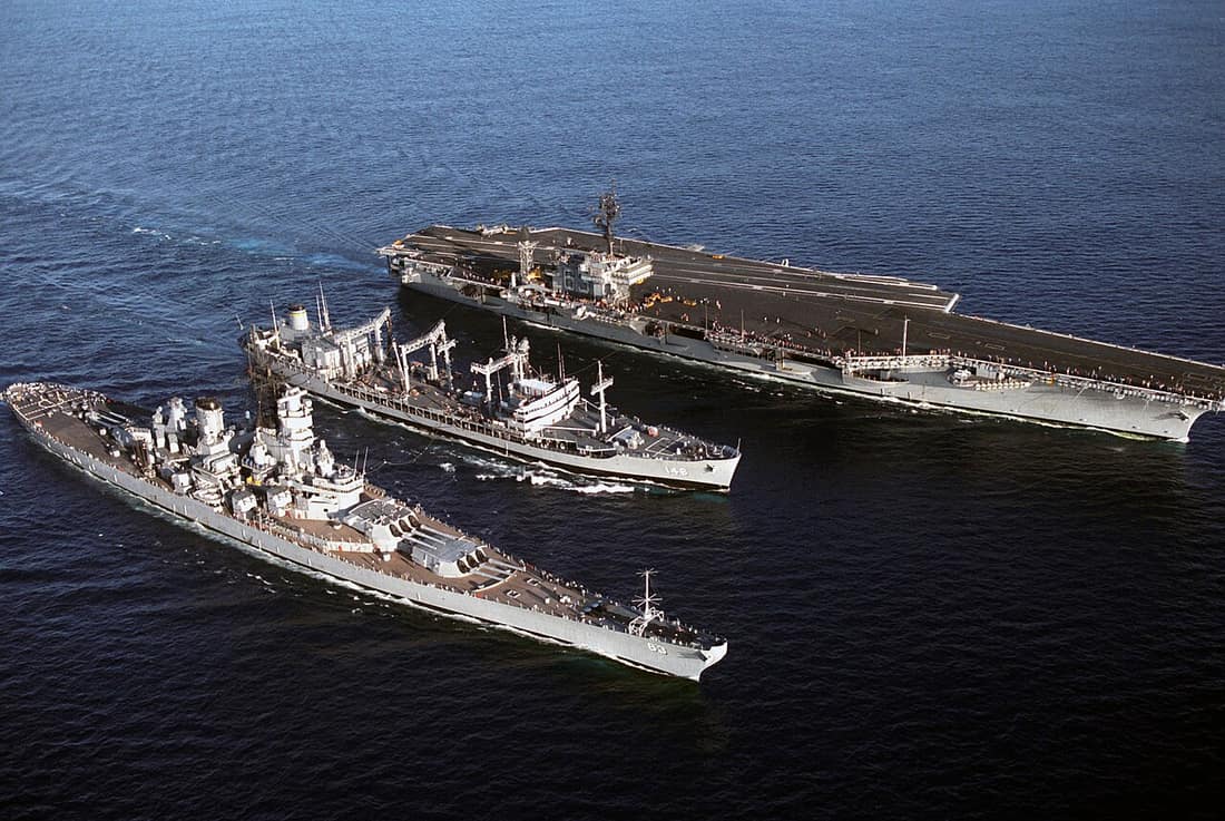 The U.S. Military Sealift Command oiler USNS Kawishiwi (T-AO-146), center, replenishing the U.S. Navy battleship USS Missouri (BB-63) and the aircraft carrier USS Kitty Hawk (CV-63) on 25 July 1986.