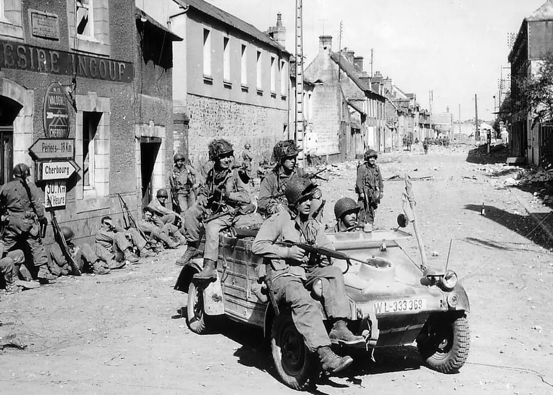 U.S. Airborne paratroopers in and on a captured VW Kübelwagen and by houses in Carentan, en:Battle of Normandy, 1944.