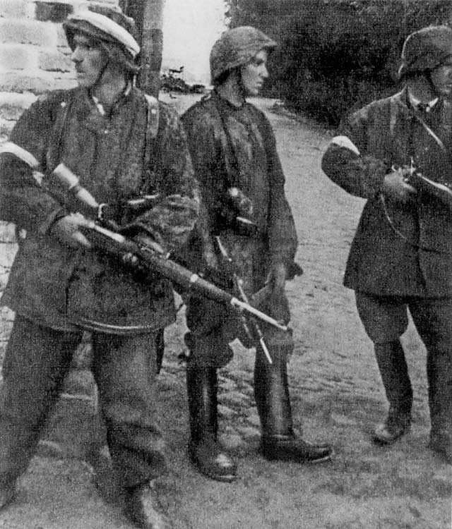 Soldiers of Batalion Zośka of Polish Home Army during Warsaw Uprising on 5 August 1944 in Gęsiówka. The men are dressed in captured German uniforms and armed with confiscated German weapons. From left: Wojciech Omyła "Wo